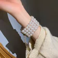 Bracelet élégant à plusieurs rangées de perles blanches avec chaîne dorée ajustable. - Blanc