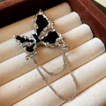 Detailaufnahme einer silberfarbenen Schmetterlingsbrosche mit schwarzen Einlagen und Sternenketten - Schmetterling Stil (HP495) / Schwarz