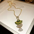 Macro detail view of a vintage fan-shaped pendant necklace with green and clear sparkling stones - Chain Only / Green