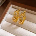 Close-up of gold chain hoop earrings with sparkling rhinestones for vintage style - Ear Buckle / Gold