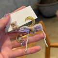 Close-up of cute pearl teddy bear dangle earrings with moon, star, and purple heart crystals - Flocking Bear Pendant Style / Silver Earring Post - Purple