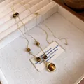 Detailed view of a vintage tiger eye beaded necklace with an elegant golden pendant - Round Pendant / Gold Brown