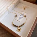 Detailed view of vintage tiger eye beaded necklace with a golden flower pendant - Flower Pendant / Gold Brown