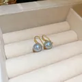 Close-up detail of gold-plated hook earrings featuring lustrous grey pearls in a display tray - Grey Pearl Ear Hook 10mm (Ear Hook)