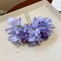 Detailed macro view of elegant handmade purple fabric flower hair pin with golden fork - Purple