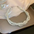 Elegante mehrsträngige Perlenkette im französischen Vintage-Stil vor Champagner-Hintergrund - Handgewebte Mehrlagige Perlenkette