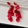 Detail shot of elegant red rose petal tassel clip-on earrings with gold chains - Clip-on Earrings / Red