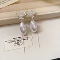 Dettaglio ravvicinato di orecchini a rosa in rete con eleganti perle e nappe - Nappina Rosa (Perno Argento) / Ago d'argento / Argento