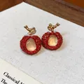 Detail view of handcrafted red resin lychee earrings featuring elegant gold zircon stems - Earrings / Gold-Red