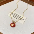 Detailed macro shot of a red resin lychee pendant necklace with elegant gold zircon accents - Necklace / Gold-Red