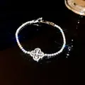 Close-up of sparkling four-petal flower zirconia bracelet with brilliant light refraction - Silver