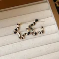 Orecchini a cerchio ondulati con trama a strisce nere e beige su vassoio portagioie - 31# Ago in Argento - Bianco