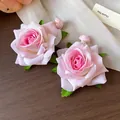 Primer plano detallado de pendientes de rosa de tela rosa con detalles de hojas verdes - Pendientes de Botón (HE30753) / Rosa