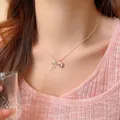 Elegant silver-toned necklace featuring a pink heart pendant and silver bow charm on a model - Silver Pink Heart