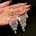 Detail view of French vintage style long tassel earrings with white pearls and zircon - Hook Style / White