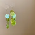 Macro detail view of layered translucent green round resin discs on gold earrings - Green