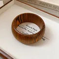 Detailed close-up of a vintage wooden bangle featuring unique natural striped grain patterns - Zebra Wood Grain Style / Dark Coffee