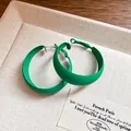 Close-up of matte forest green hoop earrings with silver pins on a beige textured jewelry tray - 44# Forest Green