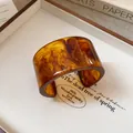 Close-up of wide resin cuff bracelet featuring artistic brown wood grain texture. - Amber Brown Wood Grain Open Style / Brown