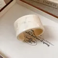 Close-up of a retro marble pattern wide cuff bracelet featuring an elegant cream finish - Off-White Marbling Style / Off White