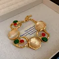 Elegant vintage gold court style bracelet with red and green stones and shell inlay detail - Bracelet / Gold-Green