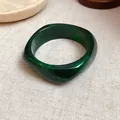 Macro view of a dark green marbled resin bangle featuring a geometric square design. - Dark Green