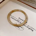 Close-up macro detail of retro wood grain pattern resin bangle bracelet for women jewelry - Classic Ring Style / Off White