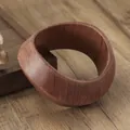 Handmade irregular wooden bangle featuring a natural reddish-brown grain and organic shape - Mobius Twist Style / Dark Coffee