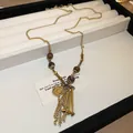 Close-up of bohemian beaded necklace with gold coin pendant and chain tassels - Style 2 Necklace / Gold and Tassel