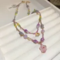 Close-up of bohemian beaded necklace with pink flower pendant on jewelry tray. - Style 37 Necklace / Pink and Floral