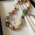 Close-up detail of bohemian necklace featuring colorful ceramic beads and textured gold spacers - Style 36 Necklace / Gold Beaded