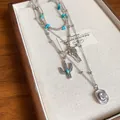 Detailed view of a bohemian layered necklace featuring bull skull and cactus charms - Style 38 Necklace / Silver and Pendant