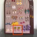 Large display board showcasing a variety of floral and butterfly dangle earrings - Size 9