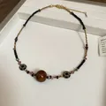 Handmade bohemian beaded necklace featuring a tiger's eye pendant and golden sun charms - Style 41 Necklace / Coffee and Round Beads
