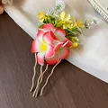 Gros plan d'un élégant pic à cheveux floral en tissu avec un motif de frangipanier - Bâton à cheveux / Rouge