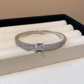 Détail en gros plan d'un élégant jonc ovale argenté orné de diamants pavés scintillants - Jonc-Argent (WB1710)