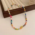 Handmade colorful beaded necklace featuring a yellow smiley face and pink flower - Colorful Smiley Flower Necklace / Colorful