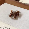 Macro detail showing the brown resin and rhinestone accents of a rocking horse brooch - Rocking Horse Brooch / Dark Coffee