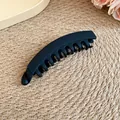 Gros plan d'une pince à cheveux minimaliste en acrylique noir mat sur un tapis - Pinces à ressort / Noir