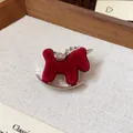 Close-up of a red flocked rocking horse brooch with sparkling rhinestone details - Rocking Horse Brooch / Red - Flocked