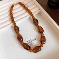 Close-up of Maillard style acrylic irregular bead necklace in warm amber tones. - Necklace / Coffee