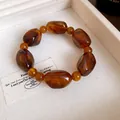 Close-up of vintage Maillard style amber acrylic beaded bracelet in jewelry tray - Bracelet / Coffee