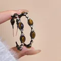 Macro view of C-shaped hoop earrings with tiger eye stones and sparkling rhinestones - Oval C-Shaped Rhinestone Inlaid Tiger Eye Stone Style / Silver Needle-Black-Coffee