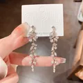 Detailed view of silver needle earrings featuring leaf-shaped dangling tassels and rhinestones - Silver - Leaf Tassel Style