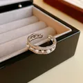 Detalle de anillo abierto ondulado plateado con pavé de circonitas y elegantes perlas blancas - Diseño de apertura ondulada / Plateado