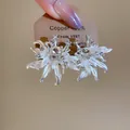 Eleganti orecchini a lobo a fiore bianco con zirconi su carta di presentazione - Argento