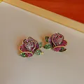 Elegant rose stud earrings with vibrant pink and green crystals in vintage gold finish. - Rose Stud Earrings with Silver Post Style
