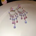 Exquisite close-up of pink zircon butterfly tassel drop earrings on a beige ceramic tray - Butterfly Water Drop Tassel Style (HE27657) / Silver-Pink