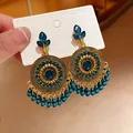 Detailed view of ethnic gold earrings with blue rhinestones and turquoise beads - Geometric Tassel Style / Gold-Blue