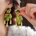 Dettaglio di orecchini vintage con perle verde smeraldo e decorazioni dorate - Stile Perno Argento - Nappina Multipla in Gemma Verde (75#) / Verde